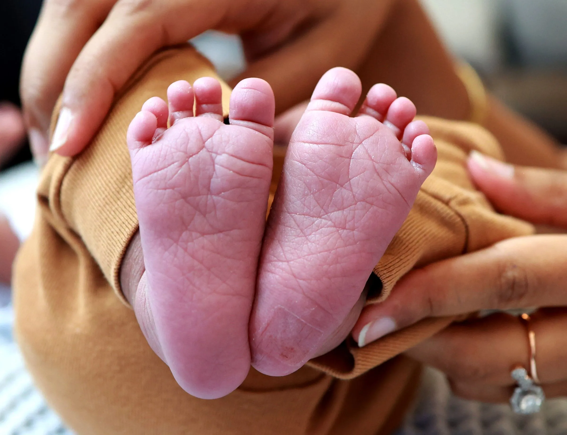 Les pieds d'un nouveau-né tenus dans des mains